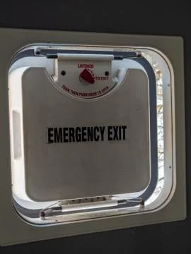 Emergency exit hatch partially open in a bus with latch and daytime Stock Photos