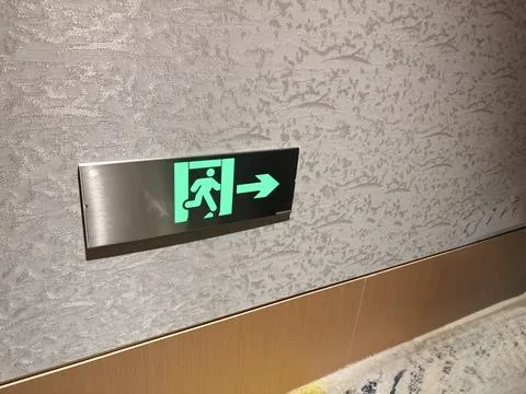 Emergency Exit Sign with Arrow on Interior Wall Stock-Fotos