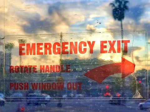 The emergency exit sign in the background of the cloudy sky Stock Photos