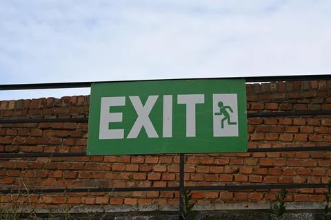 Emergency exit sign on brick wall Stockfoto's