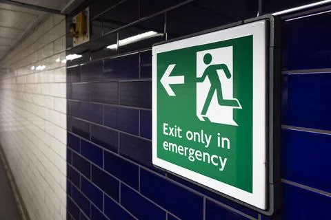 Emergency exit sign in an underground corridor Fotos Stock
