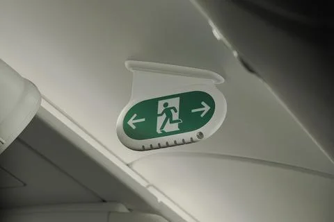 Emergency exit signs displayed inside an aircraft cabin Stock Photos