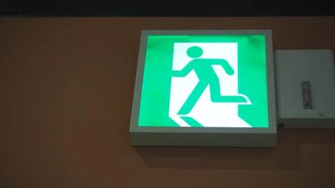 Emergency fire exit sign direction to doorway in the building .It green color Stock Photos