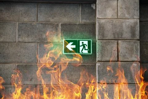 Emergency Fire Exit on the stone wall with fire flames 写真素材