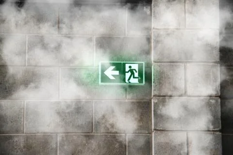 Emergency Fire Exit on the stone wall with fire smoke Stock Photos