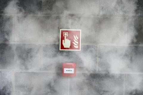 Emergency Fire Exit on the stone wall with fire  smoke Stock Photos