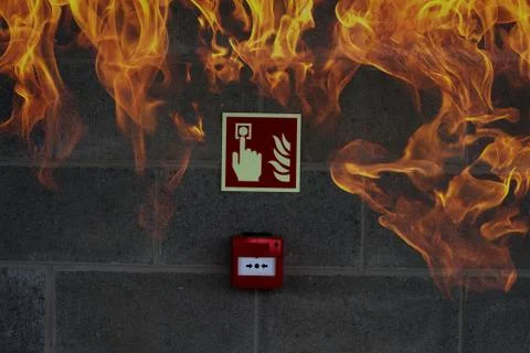 Emergency Fire Exit on the stone wall with fire flames Fotos Stock