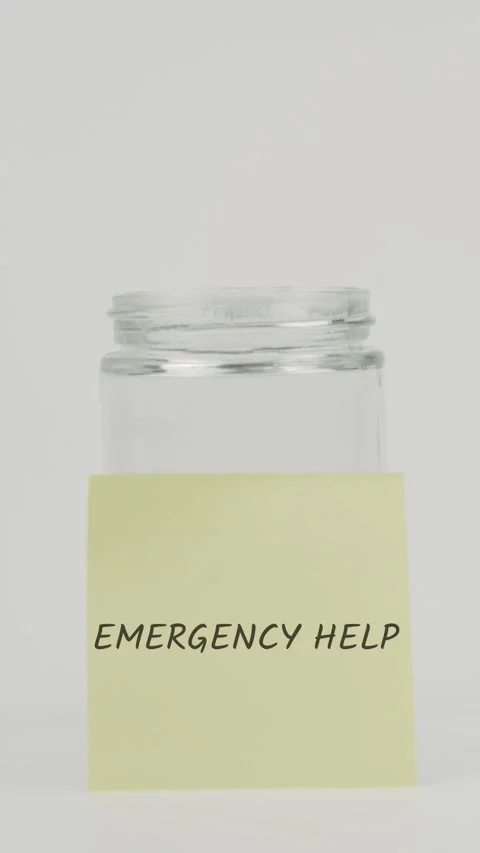 Emergency help text or word on yellow sticky note attached to glass jar Stock Footage 311725027
