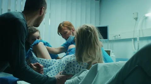 Emergency In the Hospital: Woman Giving Birth, Husband Holds Her Hand in Support Stock Footage