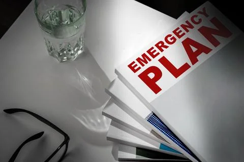 Emergency plan documents with glasses and glass of water on a table Foto stock