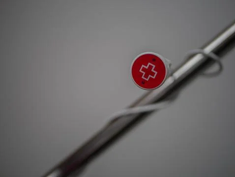 Emergency red nurse call button with medical cross symbol on hospital bed h.. Stock-Fotos