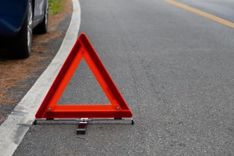 Emergency red warning triangle on the road sign with white traffic line Stock-Fotos