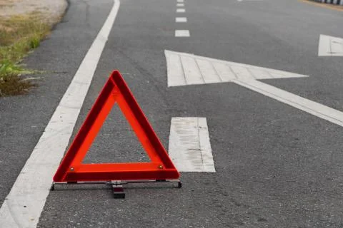 Emergency red warning triangle on the road sign with white traffic line Foto stock