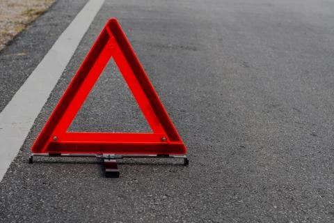 Emergency red warning triangle on the road sign with white traffic line Stock Photos