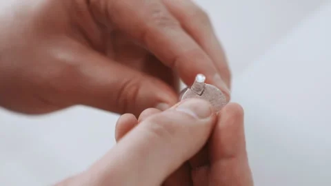 Emergency responder ensures hearing aid functionality. Proficient medic and Stock Footage 342337697
