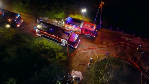 Emergency response team controls nighttime fire. Rural street with Stock Footage 232114253