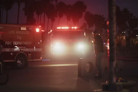 Emergency Response at Venice Beach with Fire Truck and Flashing Lights at Sunset Stock Footage 297219989