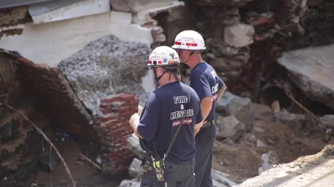 Emergency service workers at flood damaged street after a disaster. Close up. Stock Footage 70538055