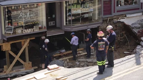 Emergency service workers at flood damaged street after a disaster. Medium close Stock Footage 70538376