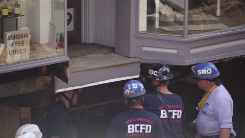 Emergency service workers at flood damaged street after a disaster. Close up. Stock Footage 70538705