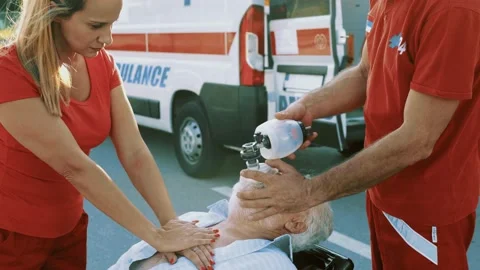 Emergency service workers provide First aid assistance to senior man Stock Footage 211819995