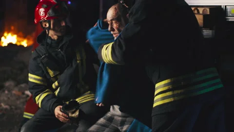Emergency service workers taking care of senior survivor Stock Footage 166145058
