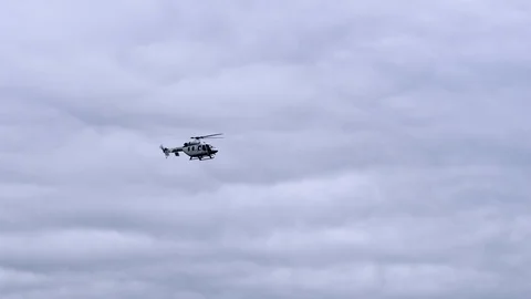 Emergency services helicopter flying fast from above in the clouds Stock Footage 111949619