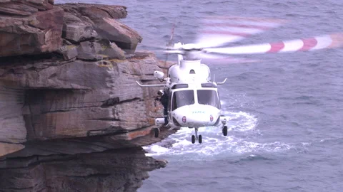 Emergency services undertake cliff rescue with helicopter in Sydney, Australia Stock Footage 132597102