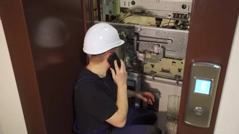 Emergency situation in elevator equipment. An engineer, worker, electrician near Stock Footage 265258400