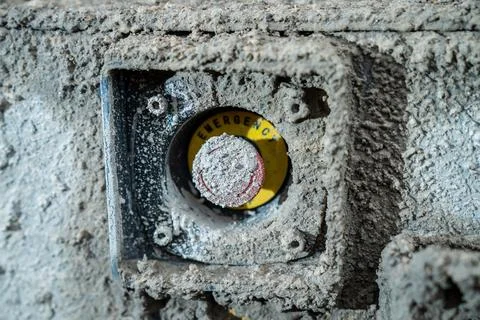 Emergency stop button on heavy construction machinery covered in dried mud Stock Photos