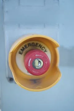 Emergency stop button located on a machine at a facility Stock Photos