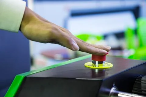 Emergency stop button push by finger for stopping machine Stock Photos