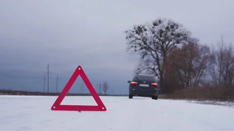 Emergency stop of the car on road side in winter. Red warning triangle Stock Footage 146342474