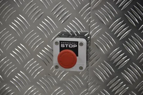 Emergency stop red button on metal wall Stock Photos