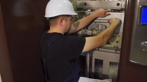 Emergency stop. A working engineer in a white helmet repairs an elevator Stock Footage 265257985