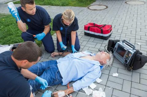 Emergency team giving firstaid to elderly patient Stock Photos
