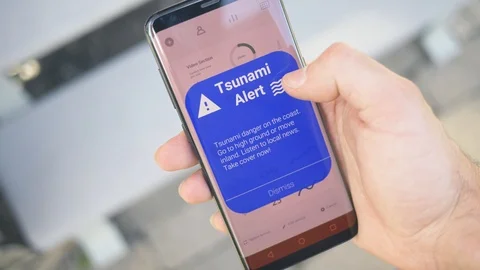 Emergency Tsunami Alert Notification on a Smartphone Screen Video stock 110802780