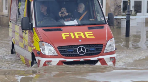 Emergency vehicles driving through flood water, Bradford on Avon, UK Stock Footage 33804086