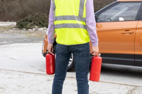 An emergency worker with a two fire extinguishers in his hand, in front of th Stock Photos