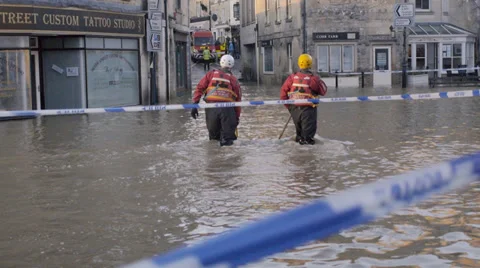 Emergency workers wading through flood water, Bradford on Avon, UK Stock Footage 33803941