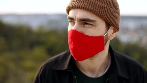 Emergency. Young man in red face mask for illness protection. Epidemic. Home Видео 128803601