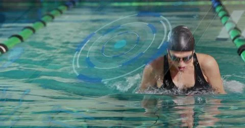 Emerging swimmer executing breaststroke pull at pool in swimsuit with cap and Stock Photos