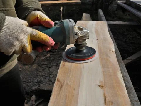 Emery processing of wood texture with a tool in the hands Stock Photos