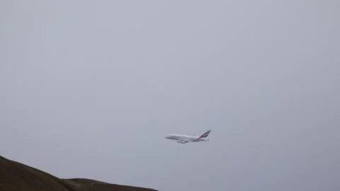 An Emirates Airlines plane passing behind the Campsie Fells. Stock Footage 278120156