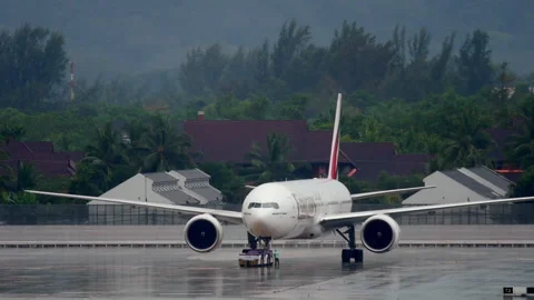 Emirates Boeing 777-300ER pushback and engine start at Phuket Airport Stock Footage 342451307