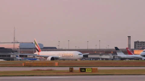 Emirates boeing 777 plane taxis from the gate at sunset Stock Footage 26284133