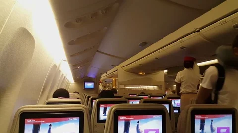 Emirates plane interior, passengers board, stewardesses talk, screens, seats Vídeos de archivo 77788486