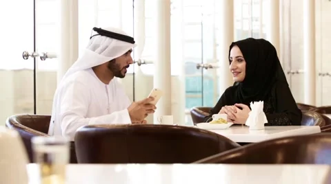 Emirati couple taking selfie using mobile camera at restaurant. Stock Footage 57337747