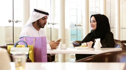 Emirati couple taking selfie using mobile camera at restaurant. Stock Footage 57337753
