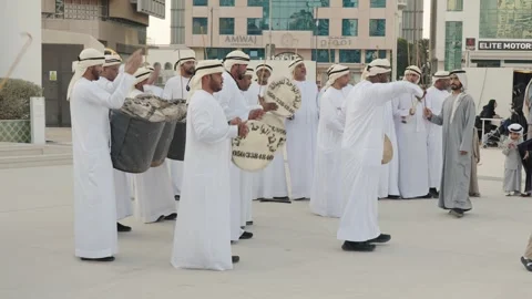 Emirati men perform a traditional dance with drums and sticks in Abu Dhabi Stockbeeldmateriaal 331390656